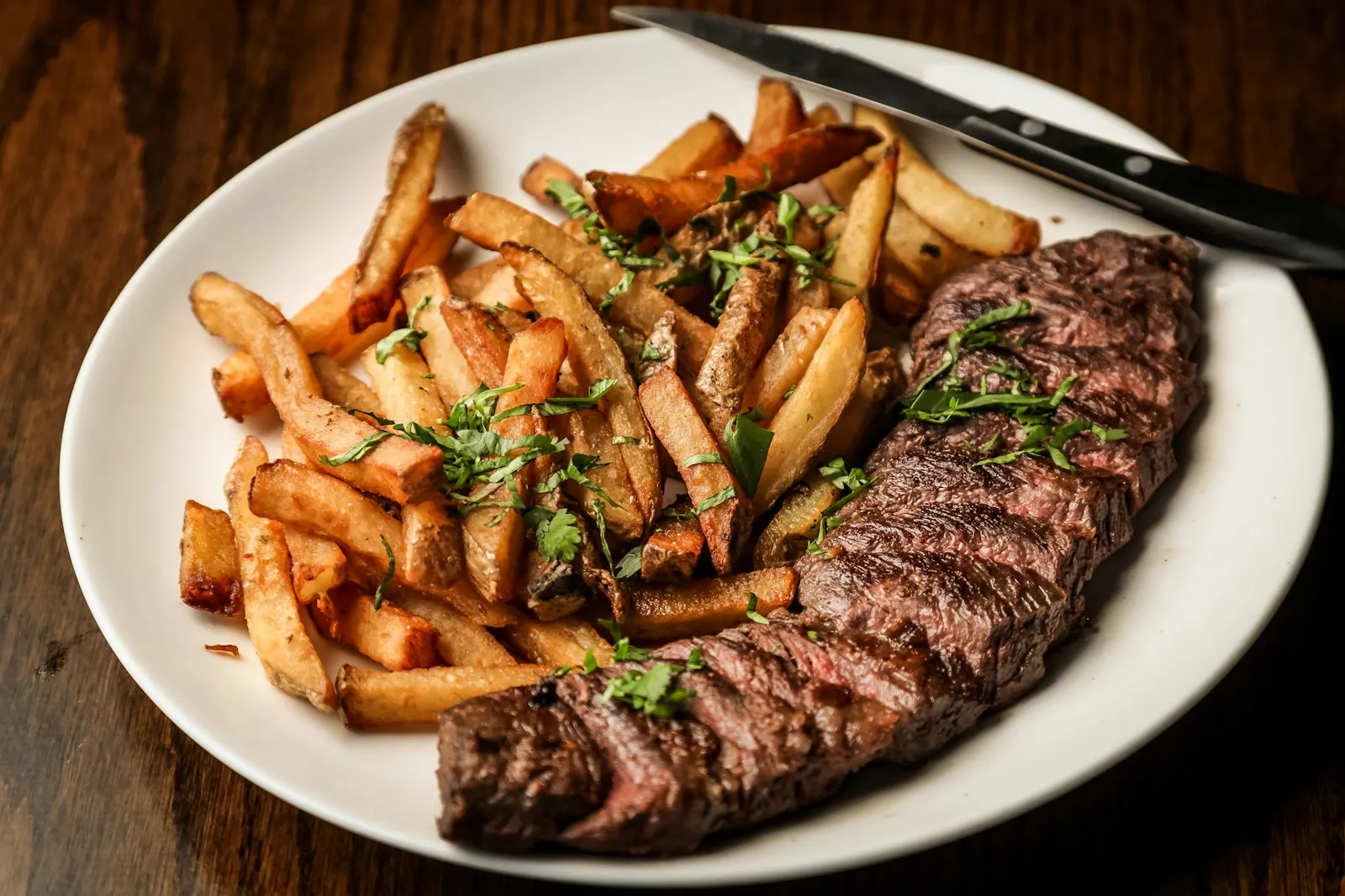 Steak and hand-cut fries plated in a restaurant kitchen